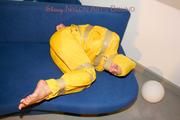 Archive girl tied and gagged by using tape on a sofa wearing an yellow rainsuit (Pics)