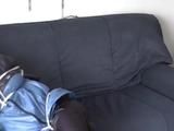 An archive girl tied, gagged and hooded two times on a sofa and chair wearing a shiny blue rainwear (Video)