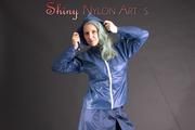 Mara posing in the studio wearing a blue rain skirt and a blue rain jacket as wellas red rubber boots (Pics)