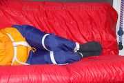Lucy tied and gagged on a sofa wearing an orange shiny nylon rain jacket and a blue rain pants (Pics)