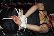 Sandra wearing a sexy black/red shiny nylon shorts and a black top being tied and gagged with ropes on a sofa (Pics)