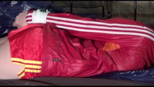 Mara tied and gagged on a princess bed in an old cellar wearing a sexy red shiny nylon shorts and a red rain jacket (Video)
