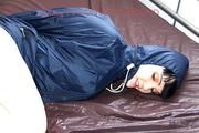 Jill tied, gagged and hooded in bed wearing a sexy green shiny nylon shorts and a shiny rain jacket (Video)