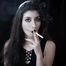 Goth girl with black eyes occasionally prefers dragging a 120mm cigarette