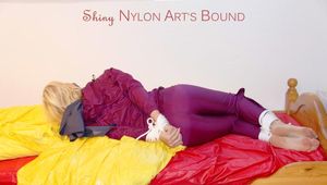 Pia in a shiny purple rainsuit tied and gagged in bed (Pics)