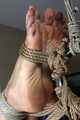 Barefoot Roxana, suspended with ropes, is tickled and teased by a camera man