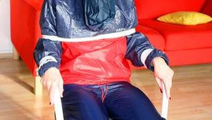 Katharina tied and gagged in a shiny nylon rainsuit
