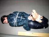 One of our archive girls tied and gagged in shiny nylon rainwear