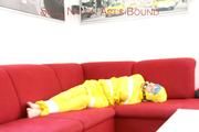 Mara tied, gagged and hooded with tape on a red sofa wearing shiny yellow rainwear (Pics)