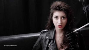 Dark-haired goddess experimenting with a cigarette holder while posing on camera