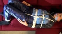 Lucy tied and gagged on a red sofa wearing a supersexy blue shiny nylon pants and a blue rain jacket (Video)