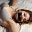 Barefoot tapegagged Grace in grey lace polka dot bra and panties, tied on the bed with her hands and legs wide-spread, wiggles helplessly