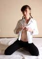 Topless barefoot Polina in unbuttoned white shirt and black jeans, bound with red ropes, poses on the floor