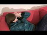 Alina wearing a sexy shiny crazy sensation skibib in blue and a green special down jacket reading on a sofa and playing with cuffs (Video)
