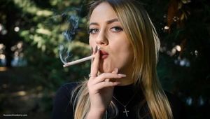 Blond lady is smoking white cigarette outdoors