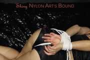 Sandra wearing a sexy black/red shiny nylon shorts and a black top being tied and gagged with ropes on a sofa (Pics)