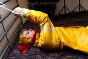 Pia tied and gagged in a shiny nylon rainsuit 