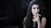 Goth girl with black eyes occasionally prefers dragging a 120mm cigarette