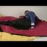 Jill in a blue shiny down jacket and black shiny rainwear tied and gagged in a shiny red/black big shiny nylon bag to lie in (Video)