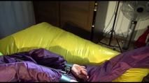 Lucy tied, gagged and hooded on bed on a bar wearing sexy purple rainwear (Video)