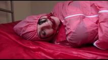 Jill tied, gagged and hooded on a bed wearing sexy pink shiny rainwear (Video)