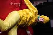 Watching sexy Pia being tied and gagged with ropes on a bed and a clothgag wearing sexy yellow shiny nylon rainwear (Pics)