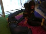 Two archive girls tied and gagged with tape on the floor wearing shiny nylon rainwear (Video)