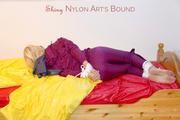 Pia in a shiny purple rainsuit tied and gagged in bed (Pics)