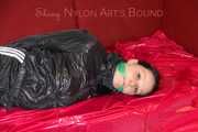 LUCY tied and gagged with ropes and a cloth gag on a sofa wearing a supersexy black shiny nylon shorts and black rain jacket (Pics)
