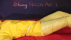 Watching sexy Pia being tied and gagged with ropes on a bed and a clothgag wearing sexy yellow shiny nylon rainwear (Pics)