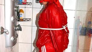 Stella tied and gagged under the shower wearing a shiny red nylon shorts and rain jacket (Pics)