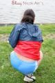 Sexy archive girl walking on a lake wearing a sexy shiny nylon shorts and an oldschool rain jacket (Pics)
