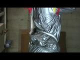 a video with Nicole tied and gagged in a shiny silver PVC sauna suit
