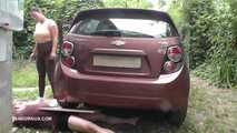 Mistress Jenna stands on the slave with a car while smoking in the slave's mouth A