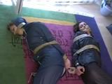 Two archive girls tied and gagged with tape on the floor wearing shiny nylon rainwear (Video)