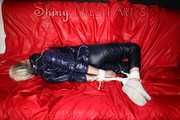 Sexy Courtney being tied and gagged with ropes and a ballgag on a bed wearing dark blue rainwear (Pics)
