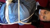 Lucy tied and gagged on a red sofa wearing a supersexy blue shiny nylon pants and a blue rain jacket (Video)