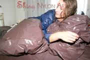 Stella wearing a supersexy blue shiny nylon rainwear while lolling in bed (Pics)