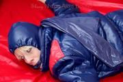 Pia hooded, tied and gagged on bed in a dark blue old school down ski suit