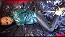 Lulu tied and gagged on a bed wearing a supersexy blue/green rainwear combination (Video)