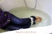 Nina tied and gagged in a shiny nylon down jacket and rainpants