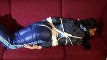 Lucy tied and gagged on a red sofa wearing a supersexy blue shiny nylon pants and a blue rain jacket (Video)