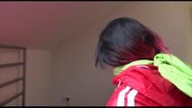 Jill tied and gagged on bed wearing a shiny light blue nylon shorts and a shiny red rain jacket (Video)