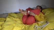 Watching Sandra  wearing an orange shiny nylon rain pants and a yellow shiny nylon rain jacket being tied and gagged on a bed with ropes and a clothgag (Video)