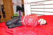 Lucy tied, gagged and hooded on a bed wearing a sexy black shiny nylon pants and a red down jacket (Pics)