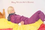 Pia in a shiny purple rainsuit tied and gagged in bed (Pics)