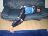 Katharina tied, gagged and hooded (breath control) on a sofa wearing sexy blue shiny nylon rainwear (Pics)