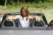 Stella tied and gagged in a grey shiny nylon catsuit in a car
