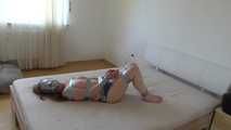 Maria in tape on bed 3/4
