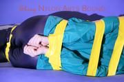 Mara tied and gagged with tape on a sofa wearing a supersexy shiny blue rain pants and a grren rain jacket (Pics) 